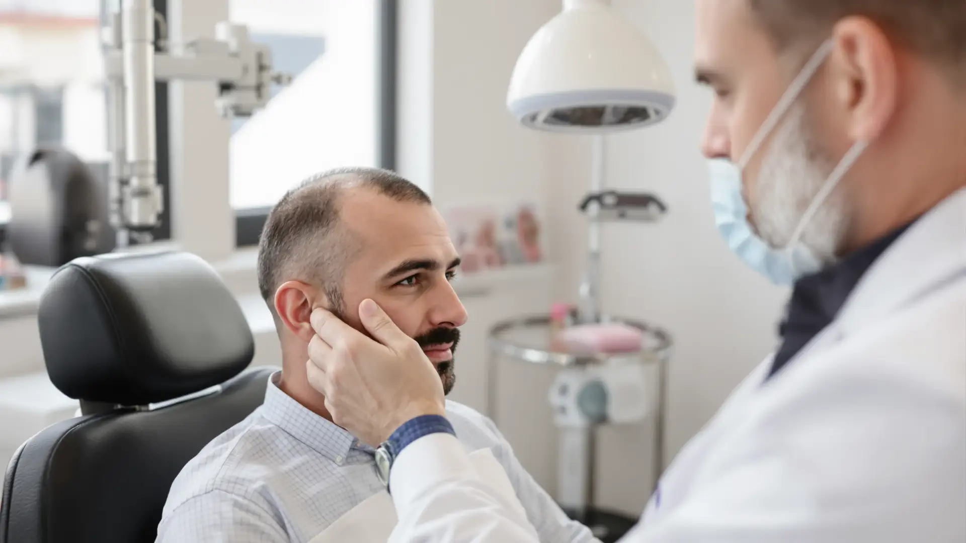 Doctor examines a patient's thinning scalp at an Istanbul hair transplant clinic